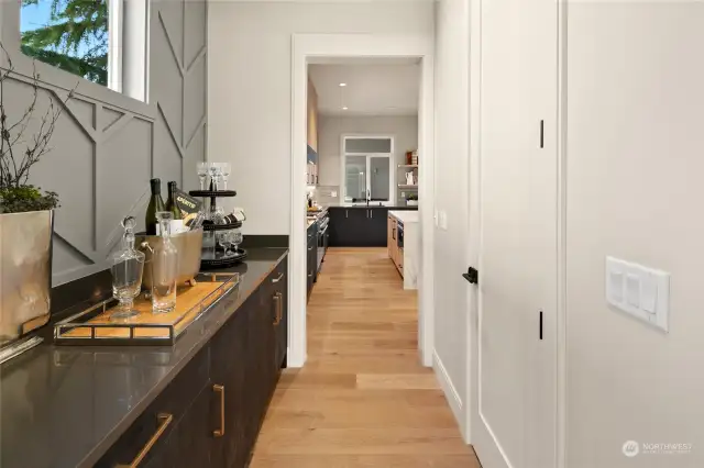 The Butlers Pantry with clear story window, custome wall design, Belmont cabinets and beverage refrigerator. The door to the right is the full walk in pantry with custom shelving.