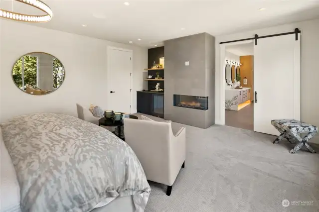 From the Primary Bedroom, enjoy a stunning view towards the elegant beverage station, cozy electric fireplace, and stylish barn door that leads to the bathroom, creating a seamless blend of comfort and sophistication.