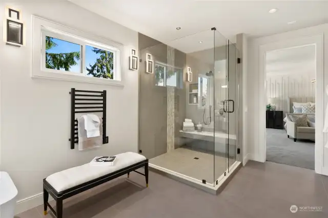 Looking from the Primary Bathroom to the double head shower with bench and towards the bedroom.