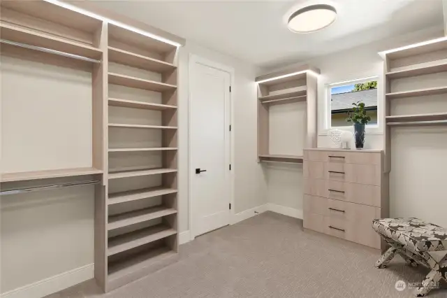 The Primary Bedroom closet is a masterfully designed space, featuring custom-built shelves and drawers for optimal organization. A charming clerestory window lets in an abundance of natural light, creating a bright and inviting atmosphere.