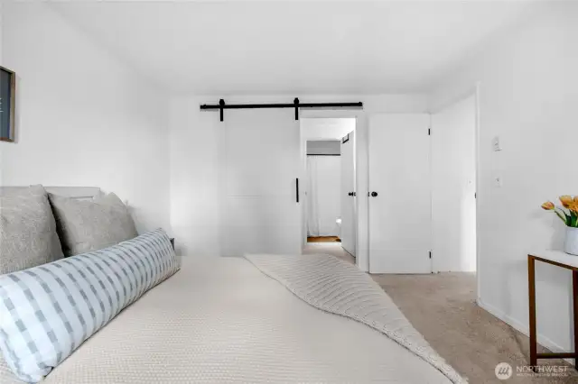 alternate primary suite view with barn door to en-suite bathroom for added privacy