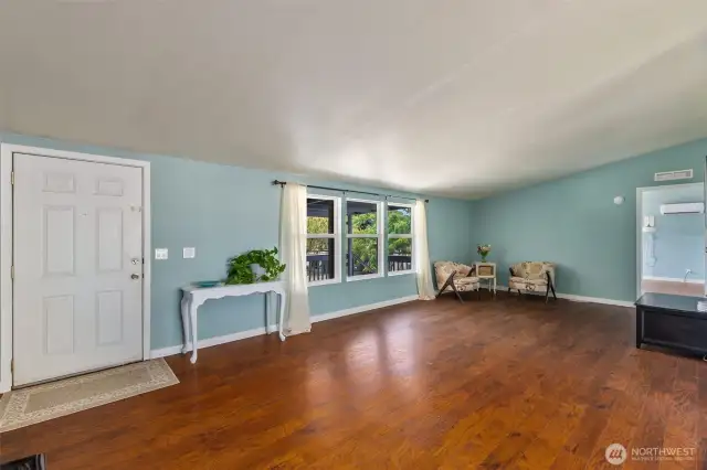 Spacious living space with beautiful laminate hardwood floors and vaulted ceilings.