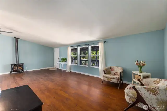 Another view of the living space and cozy propane stove with owned propane tank.