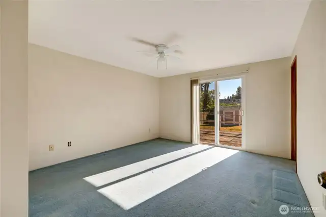 Primary bedroom w/ sliding door out to back deck