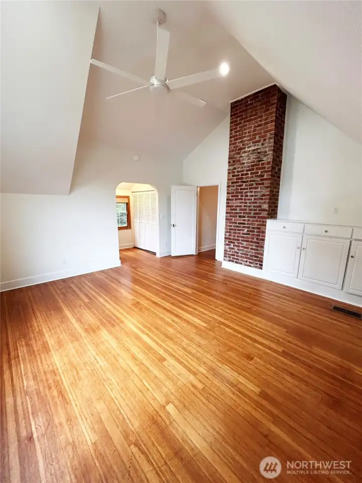 Spacious vaulted primary with two cedar closets, custom built-ins and oak hardwoods