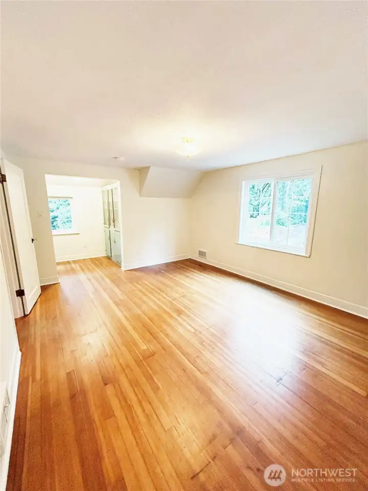 Upstairs bedroom features oak hardwood floors, custom built-in displace hutch and cedar closet.