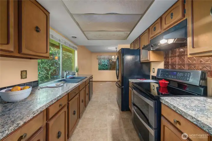 Galley-style kitchen offers plenty of counterspace for your cooking needs. Most cabinets have pull-out drawers!