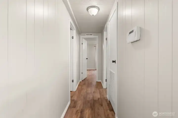 Hallway leads to both bedrooms and bathrooms.