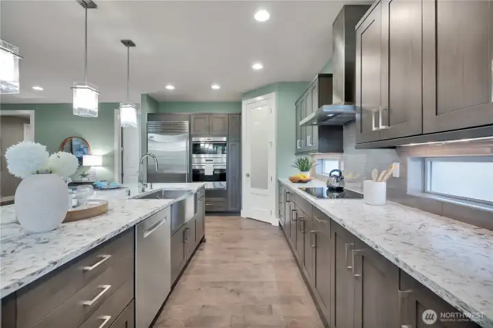 Spacious kitchen with room for more than one cook!  Wolf microwave/convection oven + standard convection oven below.  Wolf Induction Cook Top Range. Undercounter lighting as well as counter height windows.