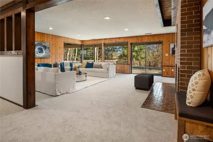 We're not done yet, this is one of several lounge areas. This rec room boasts new carpet and paint with real wood paneled walls and easy access to the back pool area.