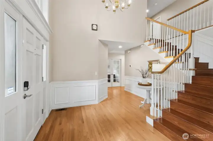 Another entry photo showing the hardwoods, stairwell and the bedroom/office towards the back.
