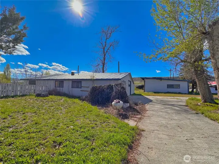 Convenient, paved horseshoe driveway leads from main road to carport and outbuildings