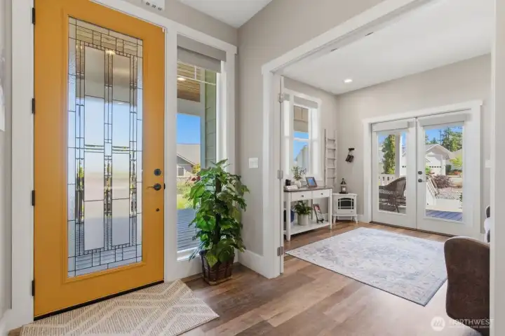 Beveled glass entry door next to den/office space with French doors to covered front porch.