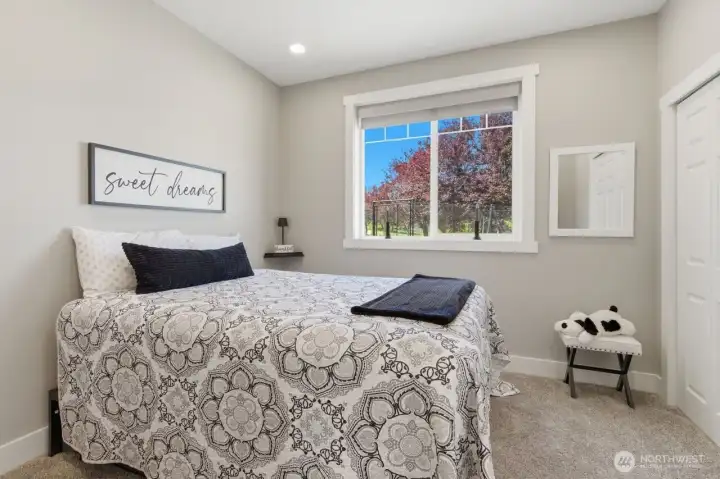Secondary bedroom with closet space and large window on to the garden area.