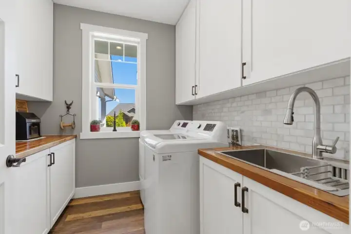 The laundry area easily accommodates full size washer and dryer, sink, cabinets and counter space.