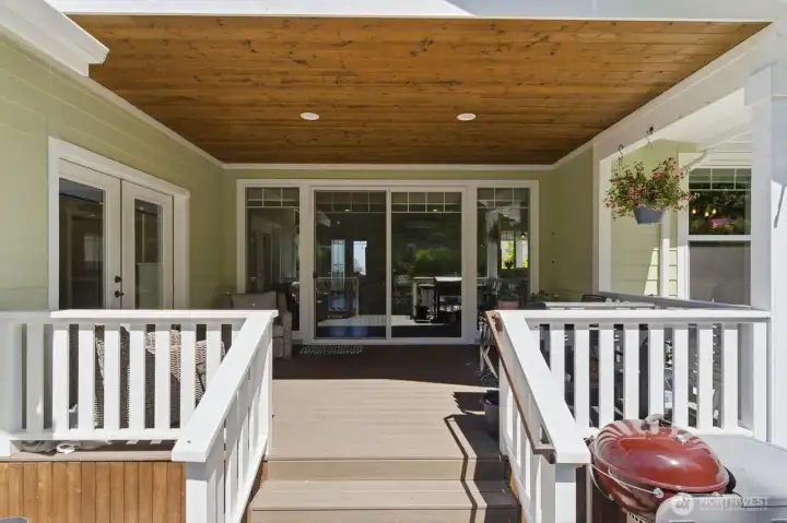 Composite decking on the floor, natural wood ceiling and recessed lighting make the covered rear deck an inviting outdoor space.