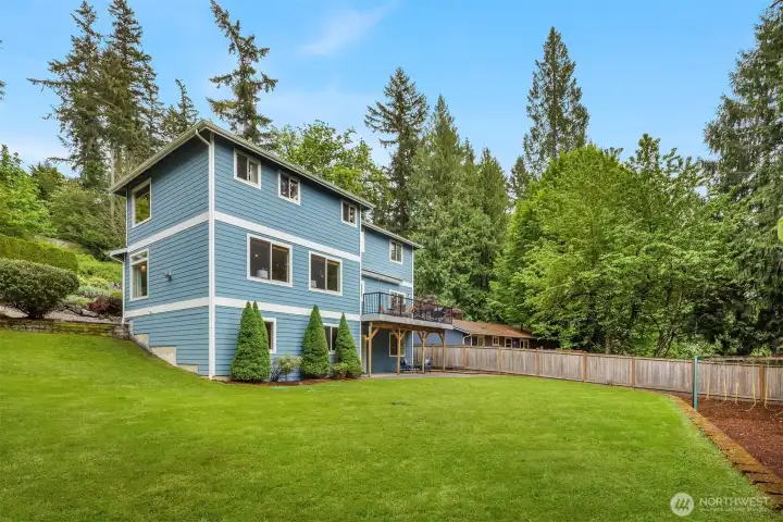 Traditional exterior with cement plank siding, a spacious deck, lower patio, and beautifully maintained yard — with a fully overhauled drainage system to keep it that way. Traditional exterior with cement plank siding, a spacious deck, lower patio, and beautifully maintained yard — with a fully overhauled drainage system to keep it that way.
