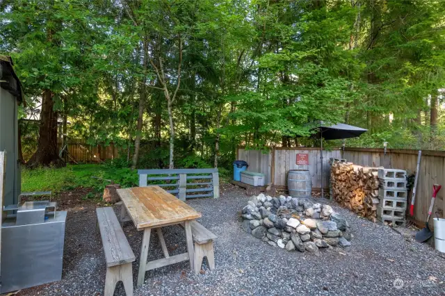 Inside the outdoor room, fire pit ready to roast marshmallows