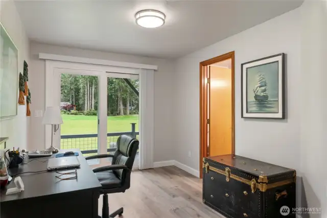 The office area downstairs with sliders leading to the deck and golf coursse.