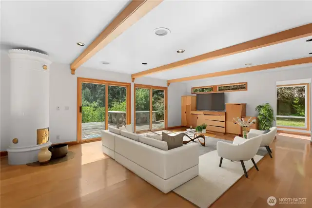 Kachelofen Stove, hardwood floors, family room with sliders to deck and outdoor bbq.