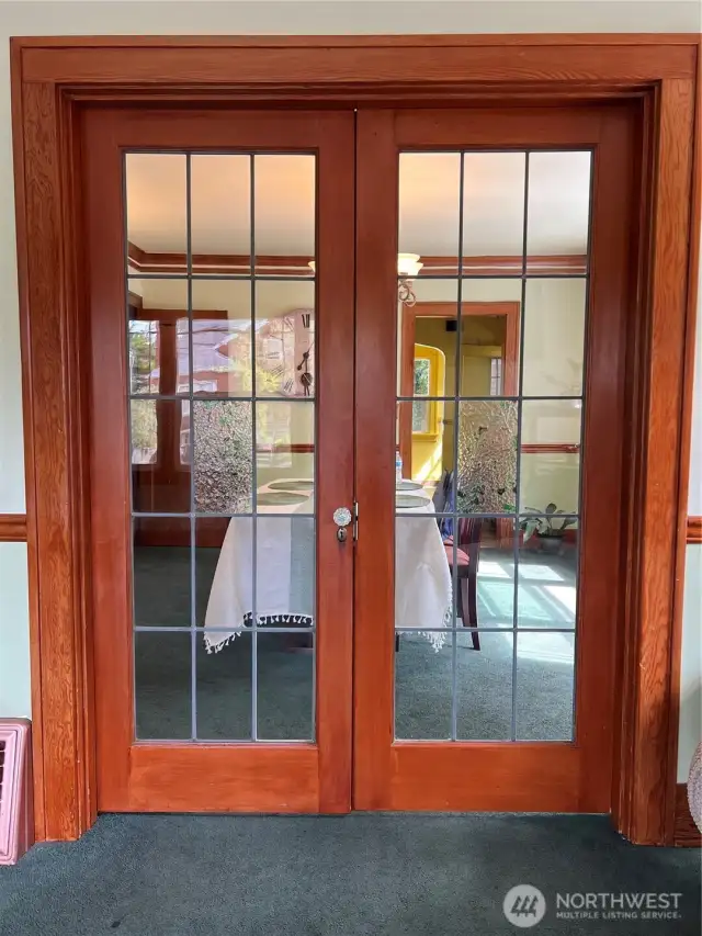 Extensive woodwork with leaded glass window french doors.