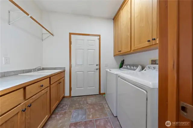 Large laundry/utility room with sink and cabinetry.