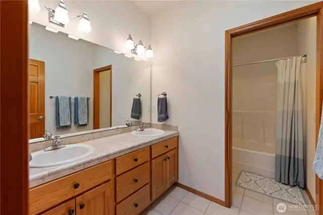 Hall or guest bathroom with double sinks and a separate shower/toilet room.