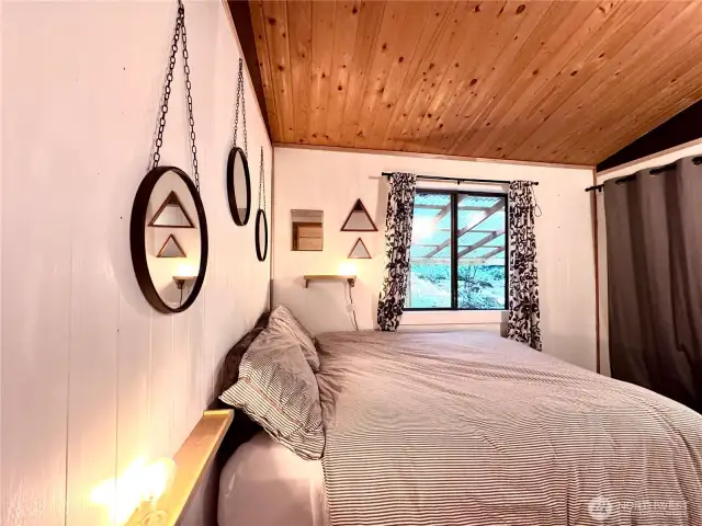 bedroom has warm wood ceilings