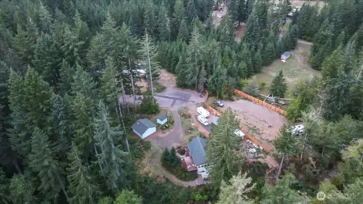 Over head drone photo shows heavy forested area to the left as part of this lot.