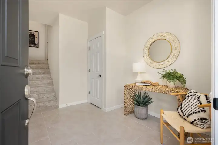 The bright and spacious entryway features neutral ceramic tile and a spacious coat closet.