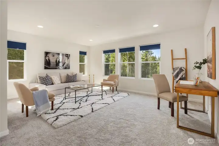 The space features picture windows and neutral carpets.