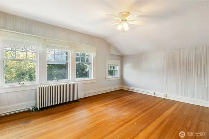 This 4th bedroom upstairs has had carpet over these wood floors for years. What a difference it makes taking out the old carpet! Love the wall of windows.