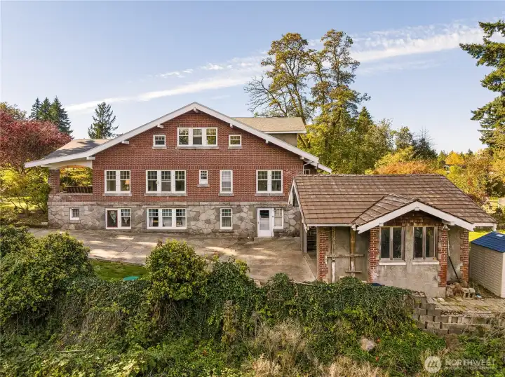 Another view of the east side of the home, and the garage at the end of the driveway. Continue past the garage to the Cottage ADU to the right.