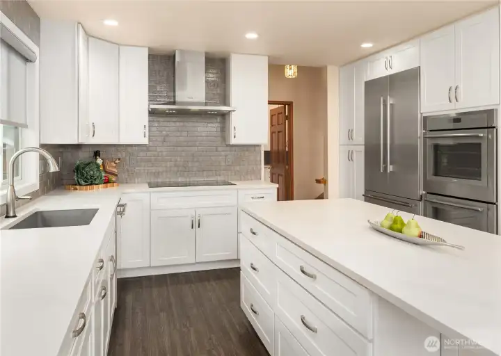 French door refrigerator/freezer, double ovens, electric cooktop and a deep kitchen sink highlight this chef's kitchen.
