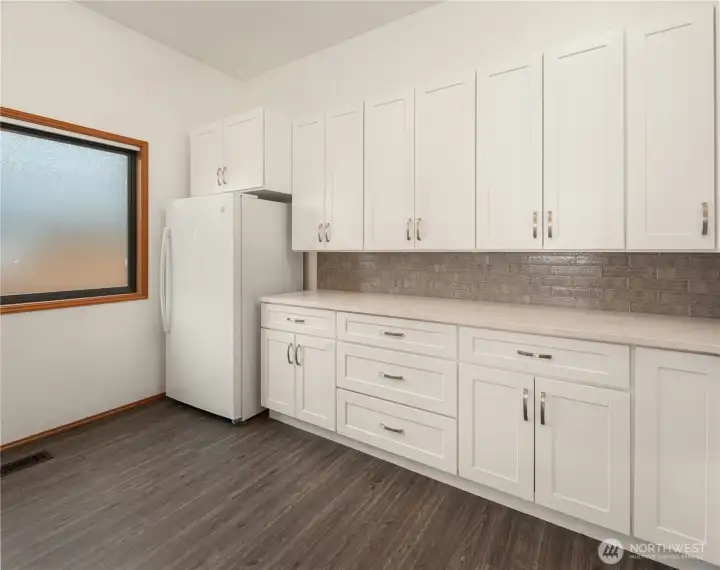 Custom spacious laundry room includes a separate freezer, W/D and additional interior storage.