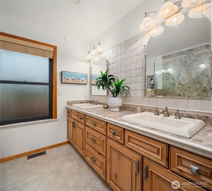 Custom finished primary bathroom includes double sinks and a large glass enclosed shower.