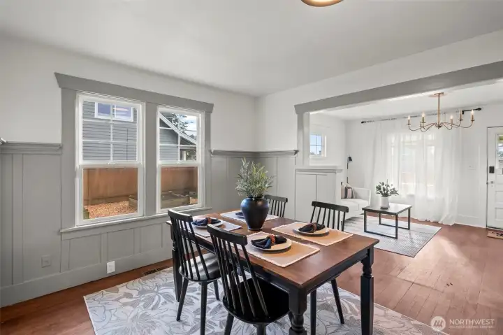 Dining area with picture windows overlooking raised garden beds