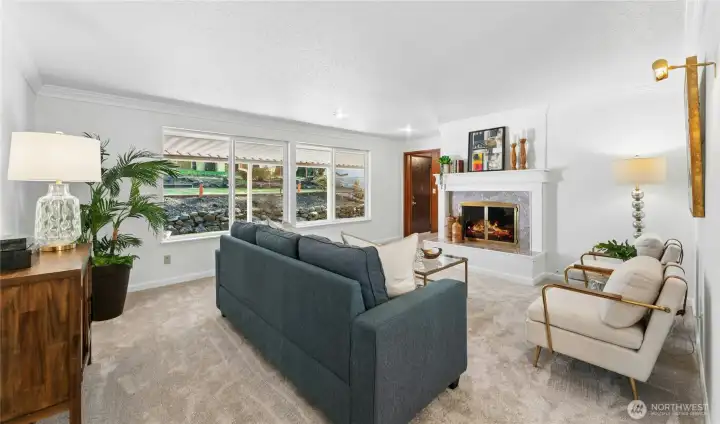 Spacious living room with wall of windows overlooking yard.
