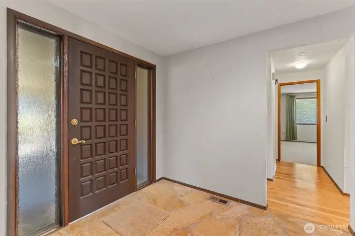 Front entrance with stone flooring. This professional, high-end entryway features durable and elegant stone flooring, welcoming guests with a sophisticated aesthetic that sets the tone for the entire home. The neutral tones and natural textures highlight the quality craftsmanship found throughout the property.