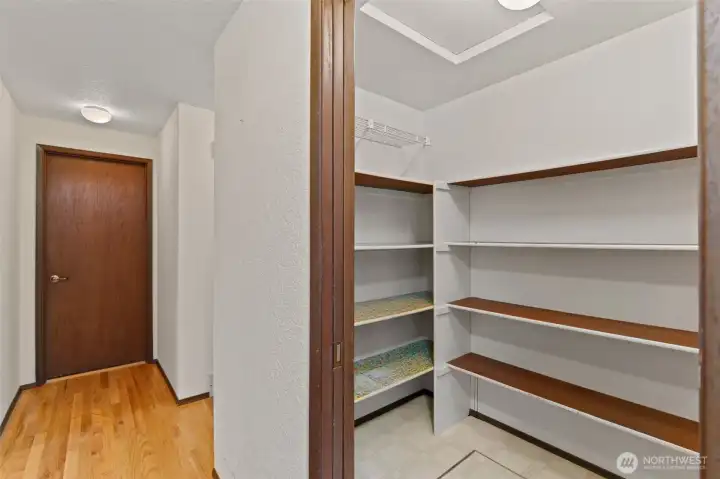 Spacious kitchen pantry with convenient garage access visible in the background.