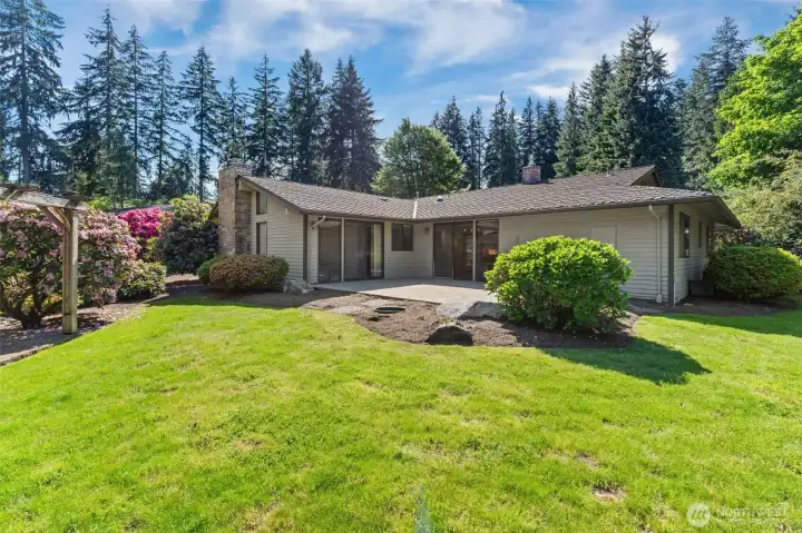 Large, secluded backyard featuring professional landscaping and a private outdoor retreat.