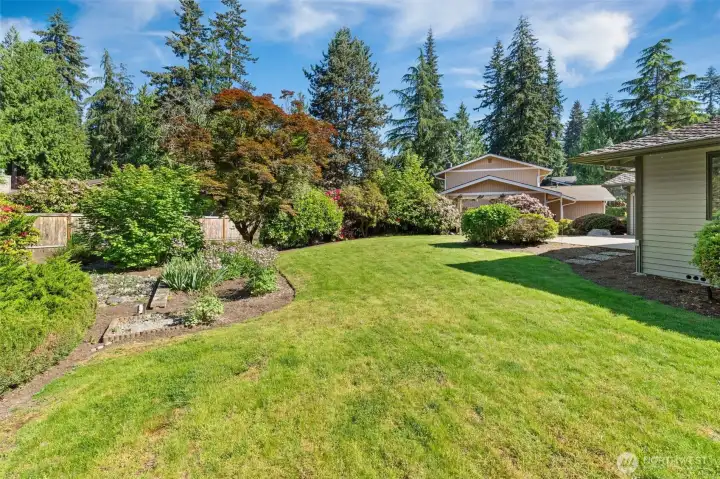 This photo captures the lush landscaping, featuring mature trees and beautiful bushes that provide excellent privacy for the property.
