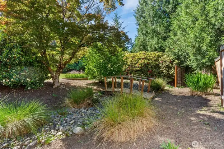 This charming bridge over river rock creates a natural, serene garden atmosphere.