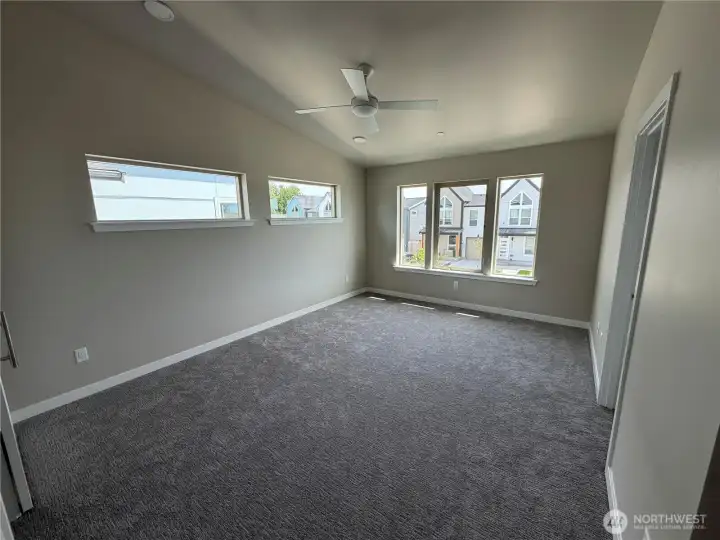 Subject property. Another view of the Primary with ceiling fan and numerous windows for natural light