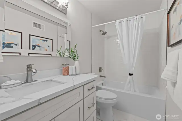 New main bath with new bathtub and tile surround.  Quartz counters w/undermount sinks AND new vanity.