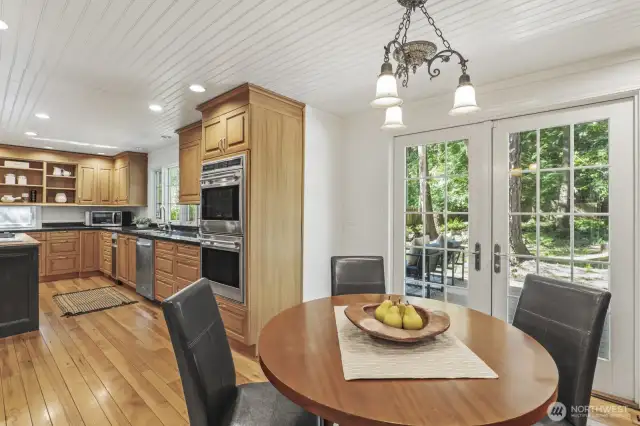 Adjacent dining area with built-in buffet and French doors to the deck and patio.