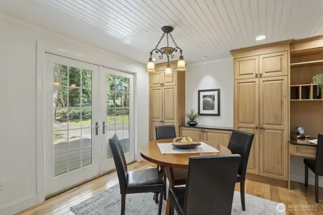 Adjacent dining area with built-in buffet and French doors to the deck and patio.