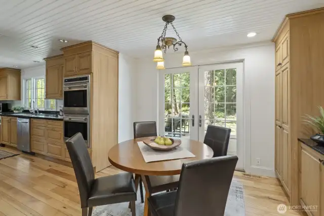 Adjacent dining area with built-in buffet and French doors to the deck and patio.