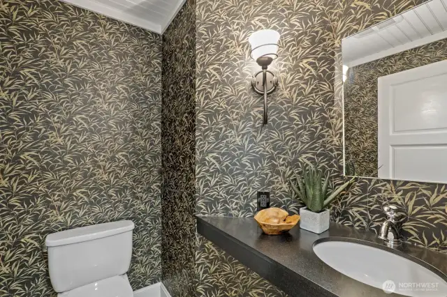 The guest 1/2 bath has been updated with a floating vessel sink, slate floor and designer wallpaper.