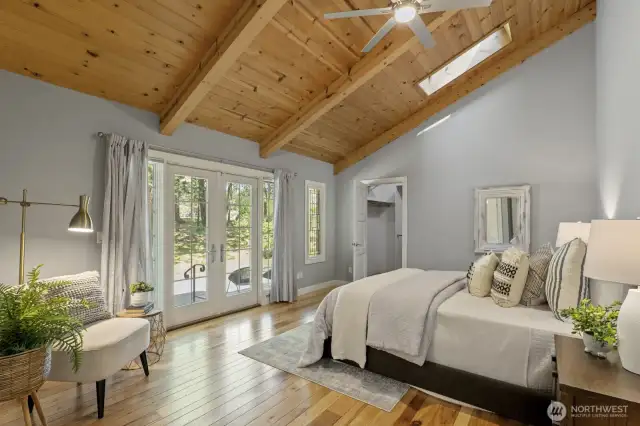 The primary suite is on the main floor features a vaulted ceiling with a skylight and ceiling fan, French doors to the backyard and patio and 5 piece bath including a soaking tub, 2 vanities, tiled shower and large walk-in closet.